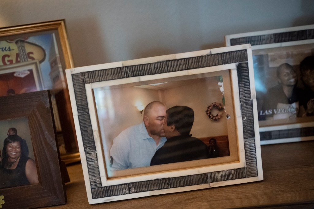 A framed photo of Melanese Marr-Thomas kissing her late husband, Charles Thomas, during their wedding ceremony, sits with other family photos, at their home in District Heights, Md